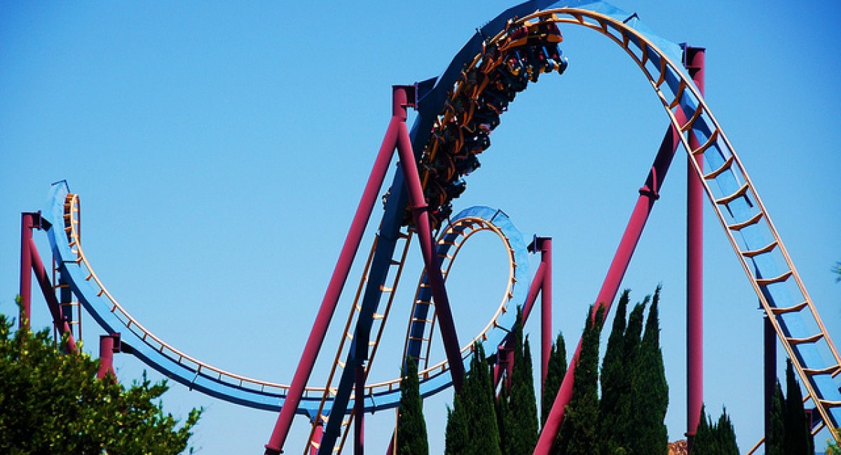 Vivid words for vivid experiences looping rollercoaster against blue sky