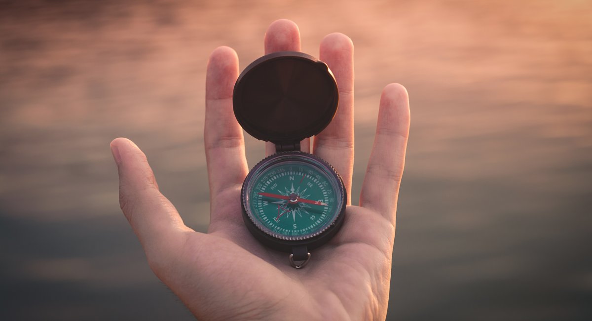 Hand holding a compass 