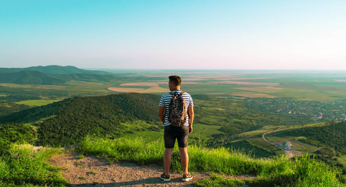 Look back at where you've come from Hiker looking back at landscape panorama