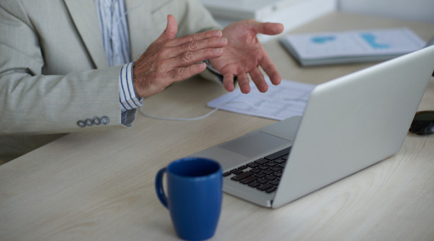 Man's hands clapping in front of a laptop