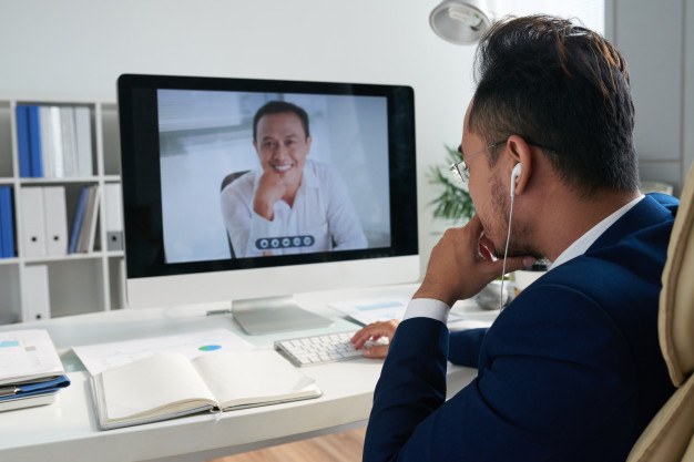 A businessman in a videoconference with another businessman.