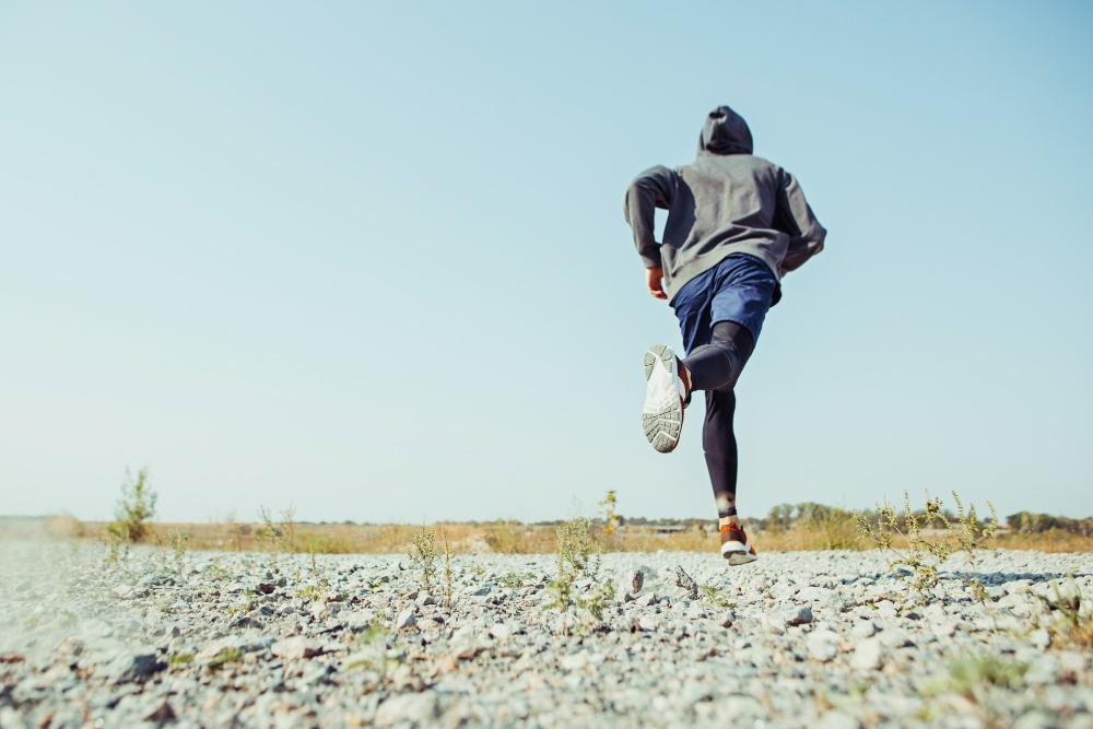 Man runner sprinting outdoor in scenic nature