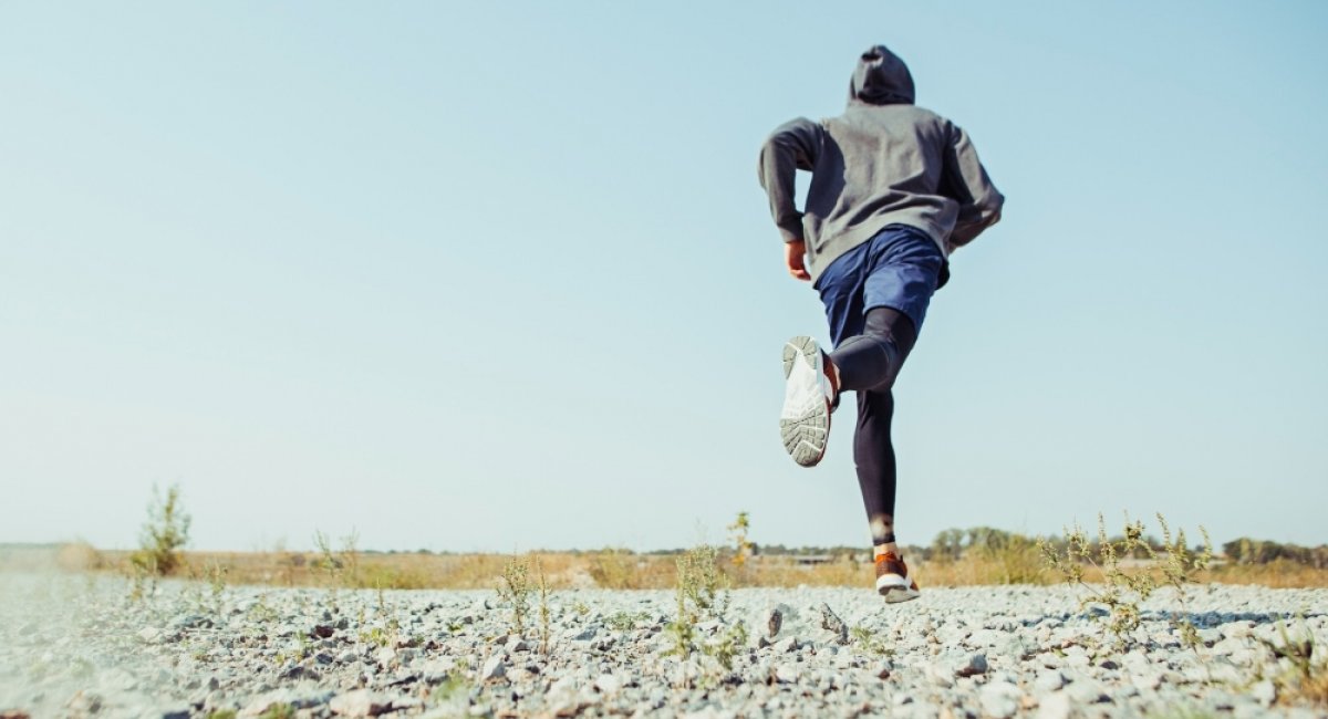 Man runner sprinting outdoor in scenic nature
