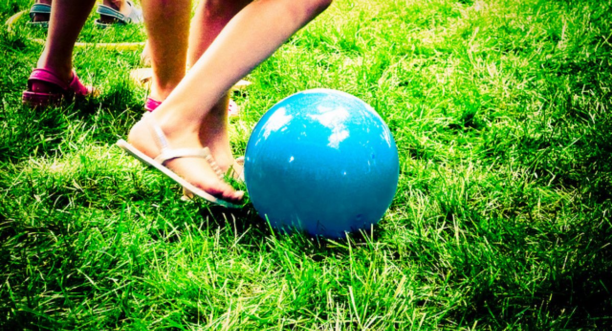 Girl's legs, kicking ball