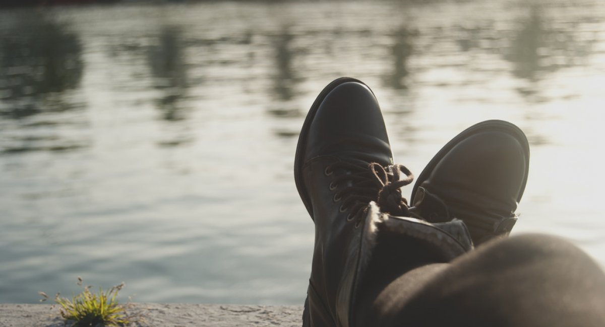 legs and feet of someone lounging by the water